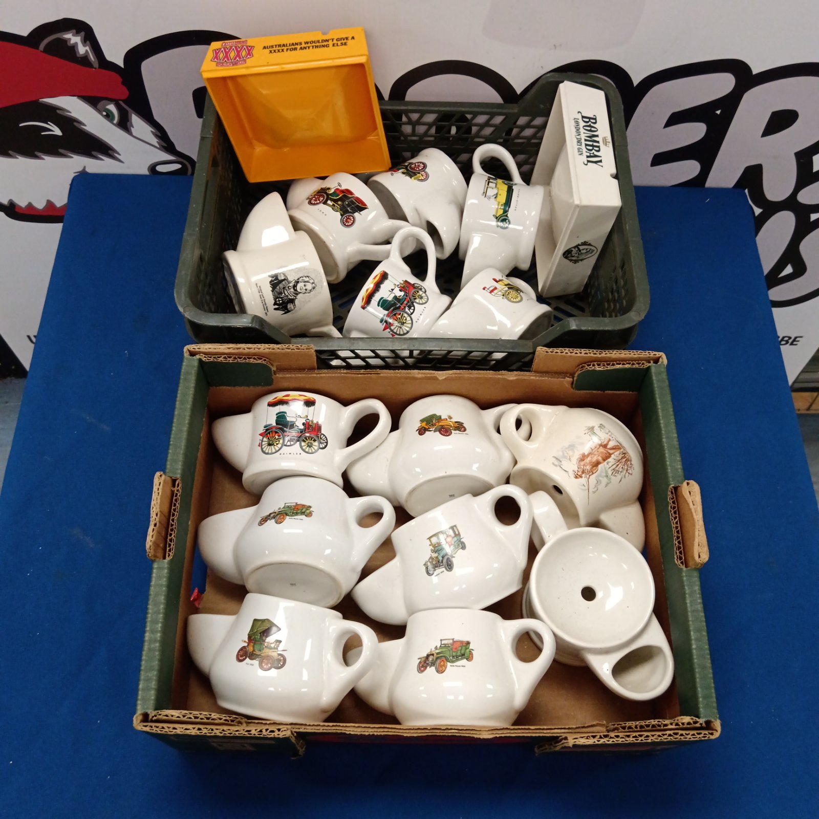 Collection of vintage Wade shaving mugs and ashtrays on display.