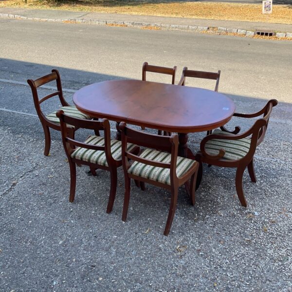 Reproduction walnut dining table with six chairs in a home setting.