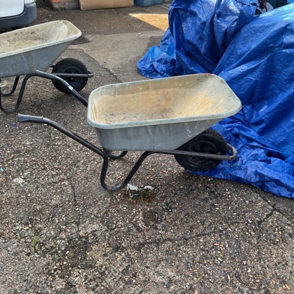 Vintage Walsall wheelbarrow in a garden setting.