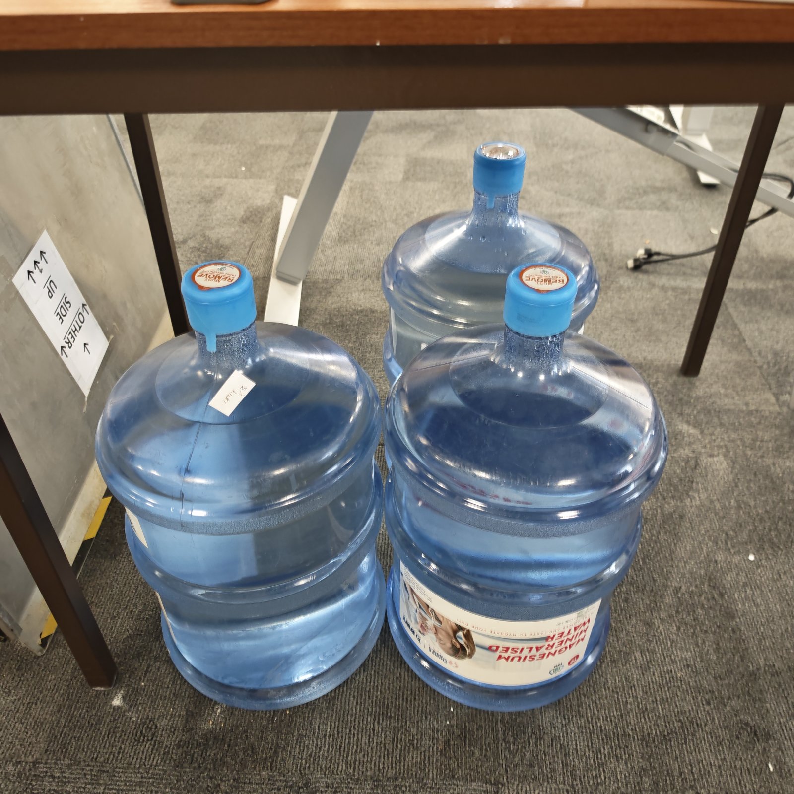 Three full water dispenser bottles for cooler use.