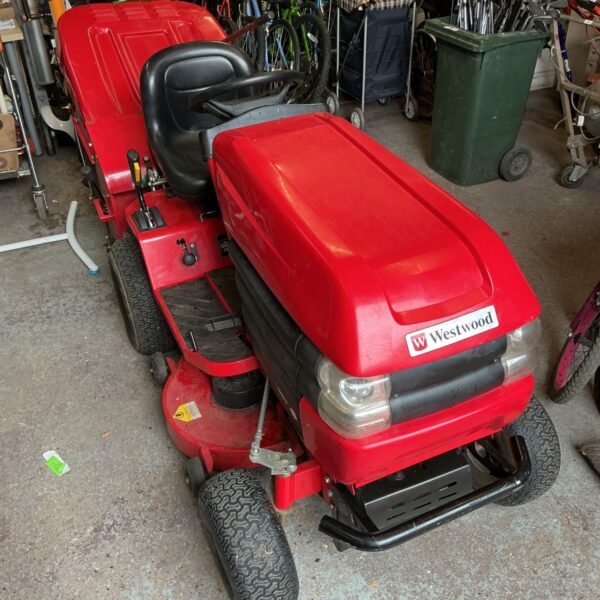 Red Westwood S1500 ride on lawnmower in a garage.