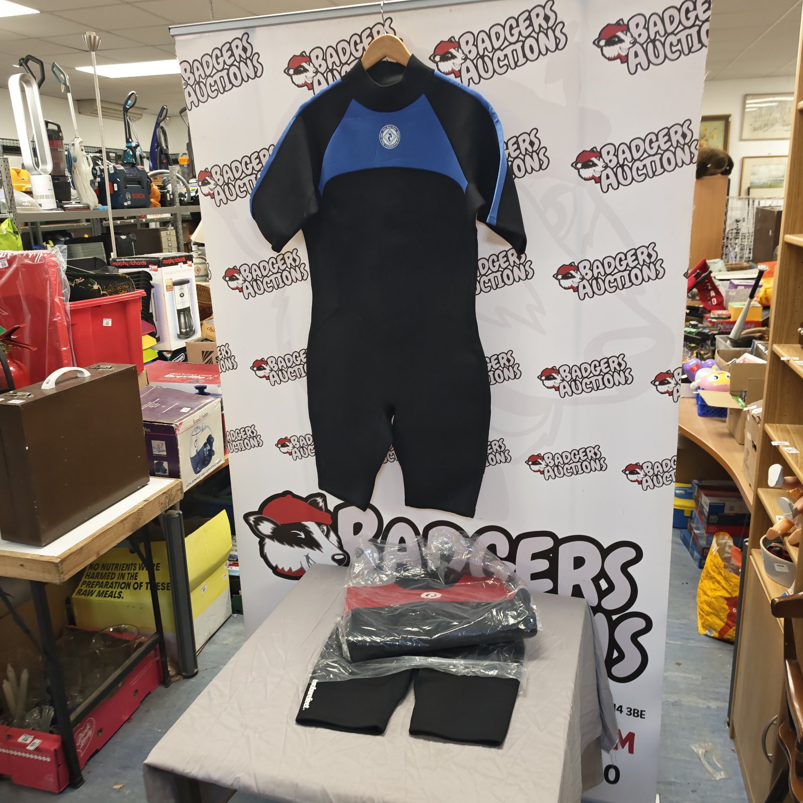 Two black and blue wet suits displayed at auction.