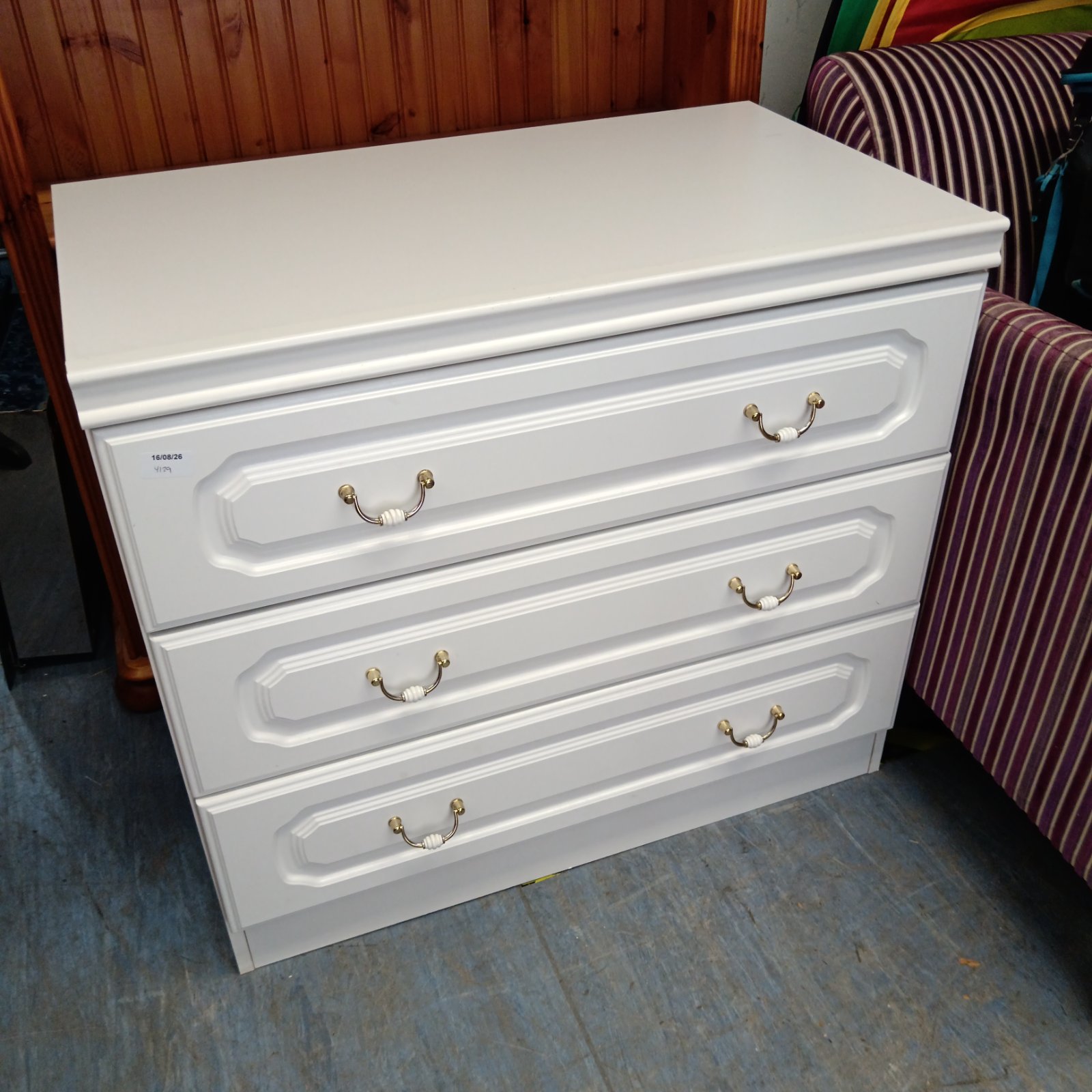White three-drawer chest of drawers for bedroom storage.