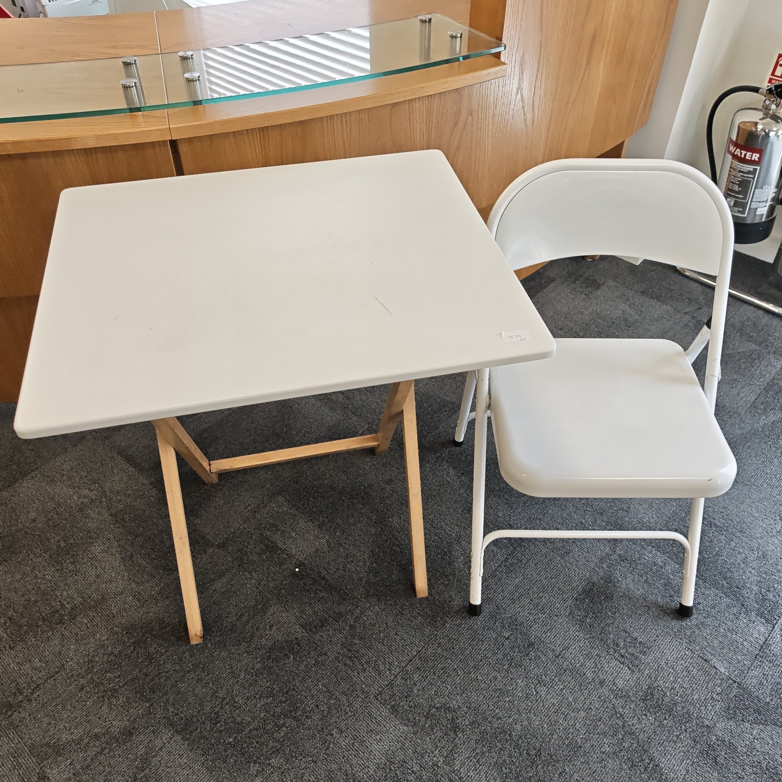 White folding table and chair set for portable seating.