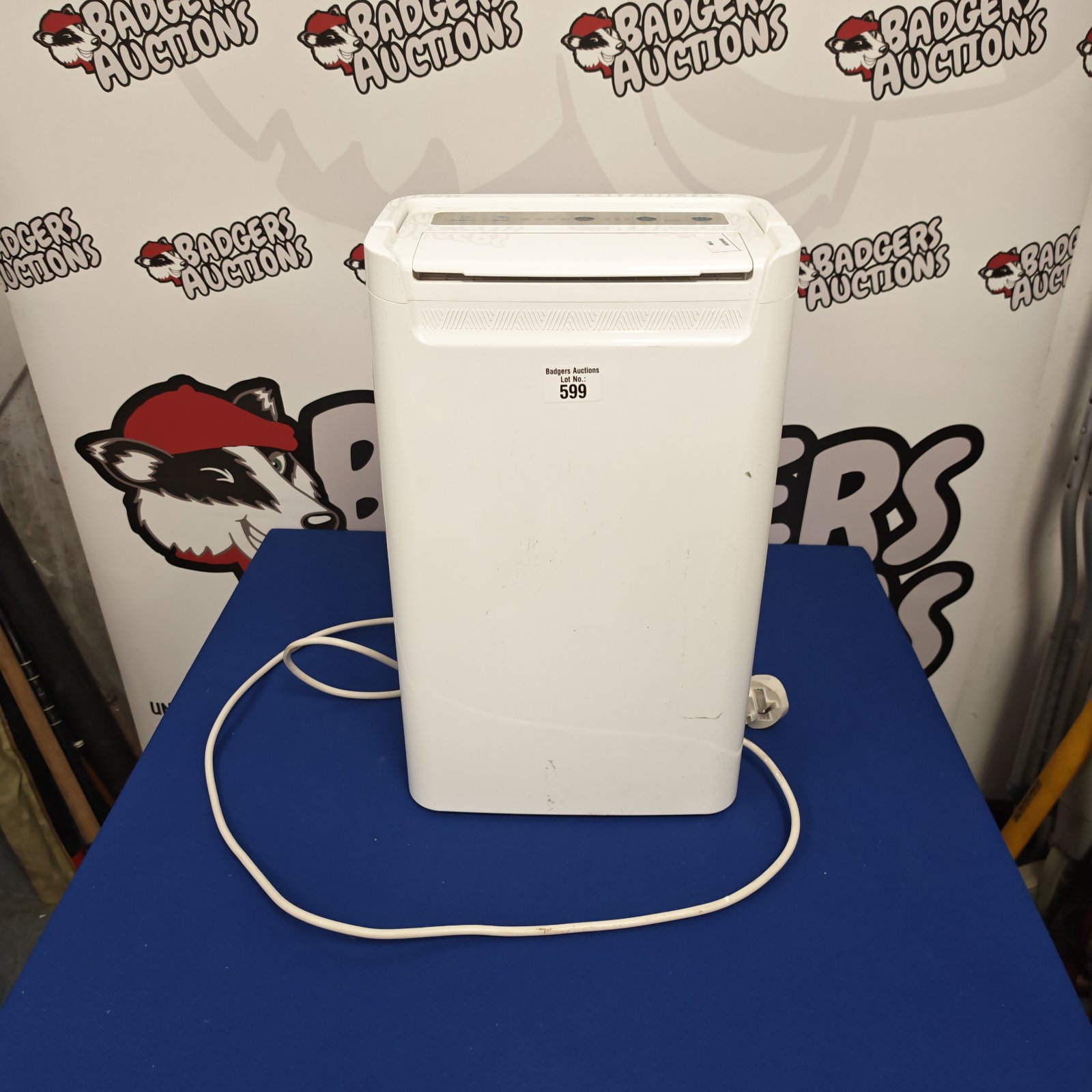White portable dehumidifier for moisture removal in a home setting.