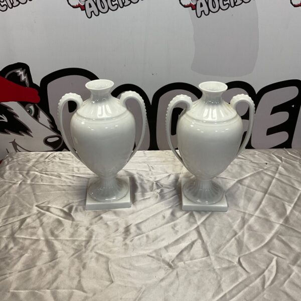 Pair of white salt glazed classical urn vases on display.