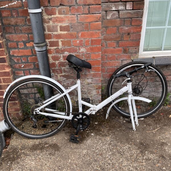 White step-through hybrid bicycle with detached front wheel.