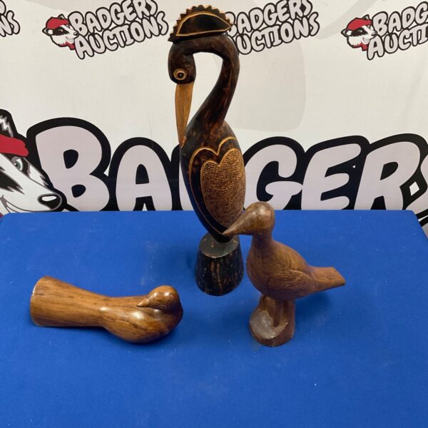 Three hand-carved wooden bird figurines displayed together.