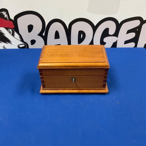 Antique wooden jewellery box with lock and key displayed.