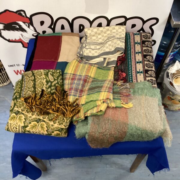 Bundle of vintage wool and cashmere blankets in various colours.