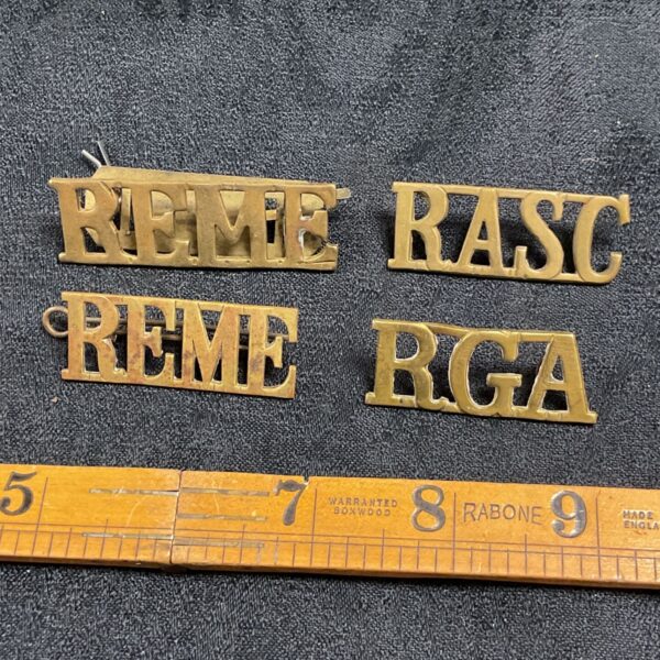 Four WW1 brass shoulder badges including REME, RASC and RGA.