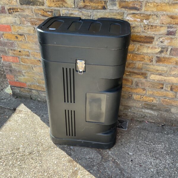 Black Zeus transit case leaning against a brick wall.