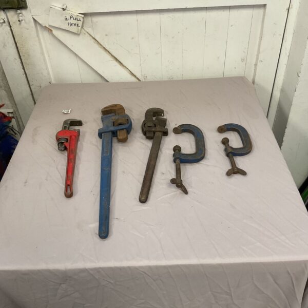 Collection of heavy duty adjustable pipe wrenches for plumbing work.