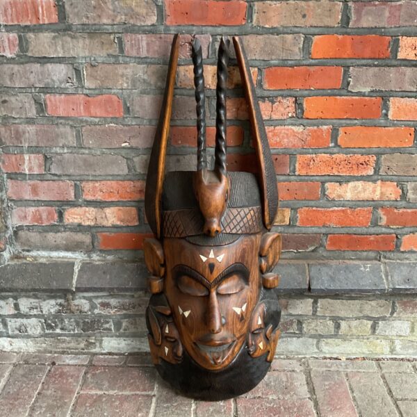 Detailed front view of a large hand-carved African tribal mask.