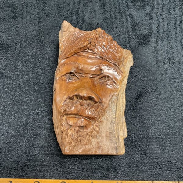 Detailed African wood carving of a man's portrait.