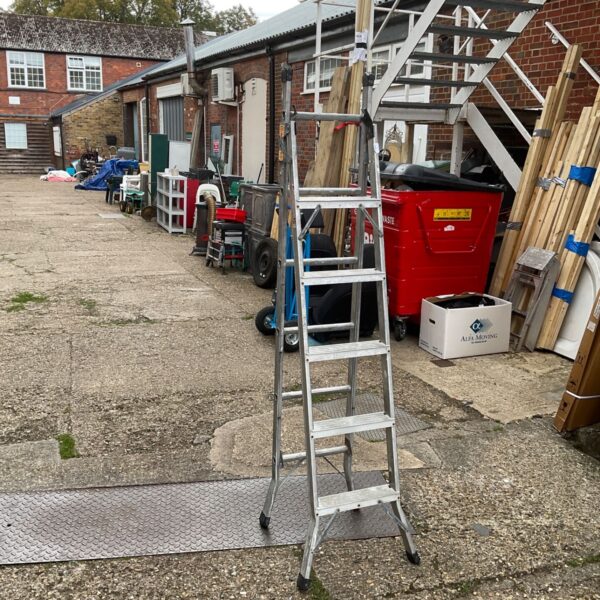 Outdoor view of an aluminium step ladder leaning against a wall.