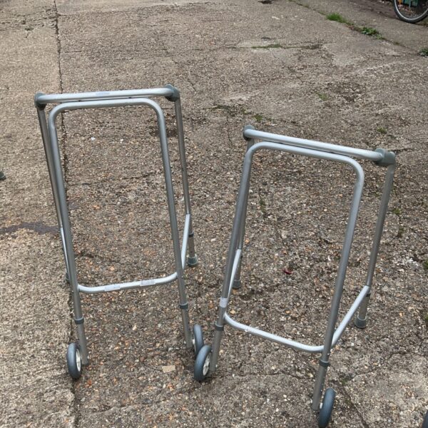 Two aluminium zimmer frames, walking aids for mobility support.