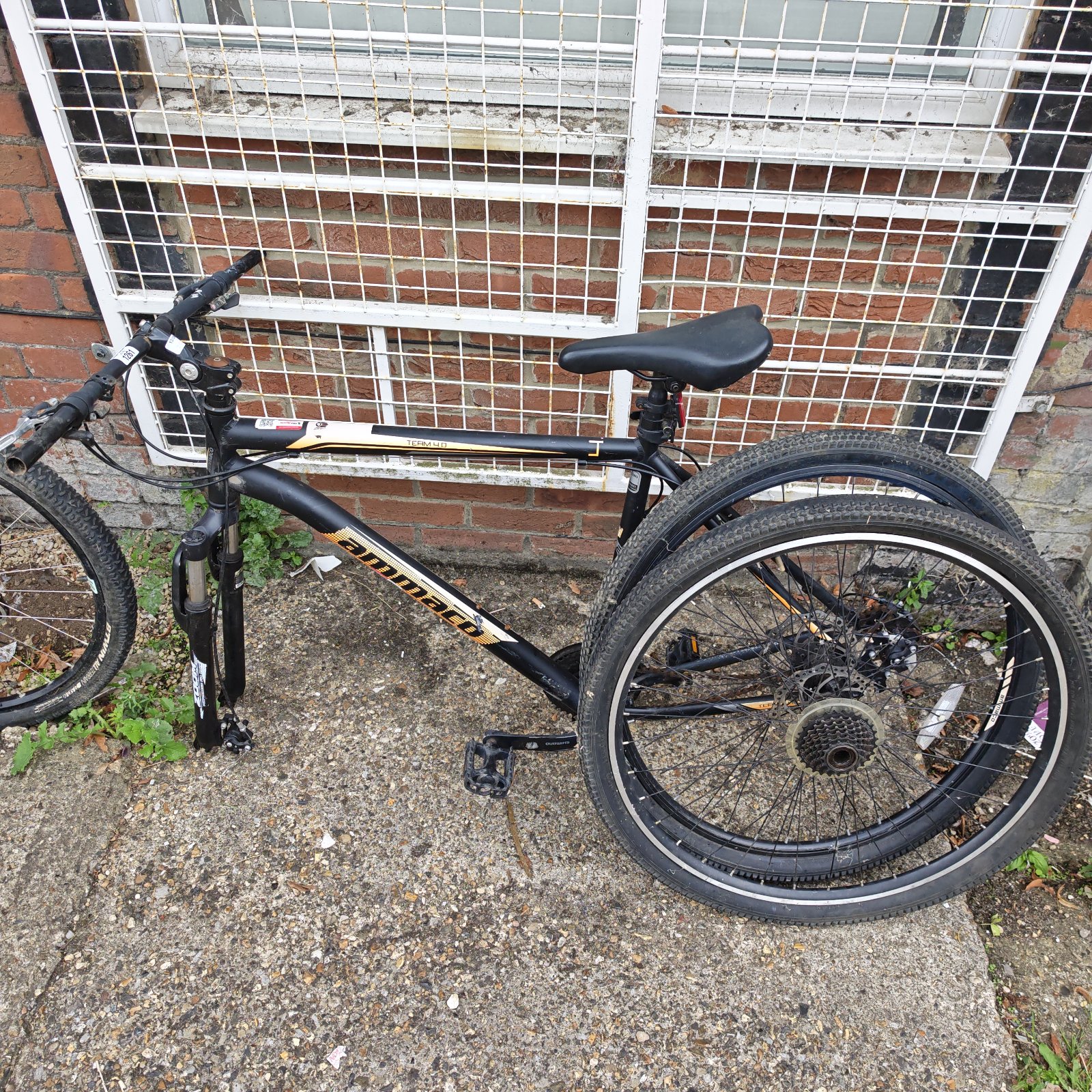 Black Ammaco mountain bike with front suspension and knobby tires.