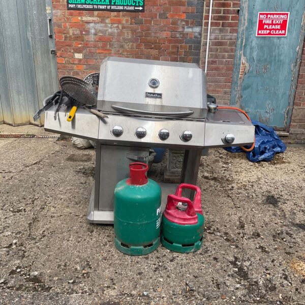 Stainless steel Anthony Worrall Thomson gas BBQ with gas bottles.