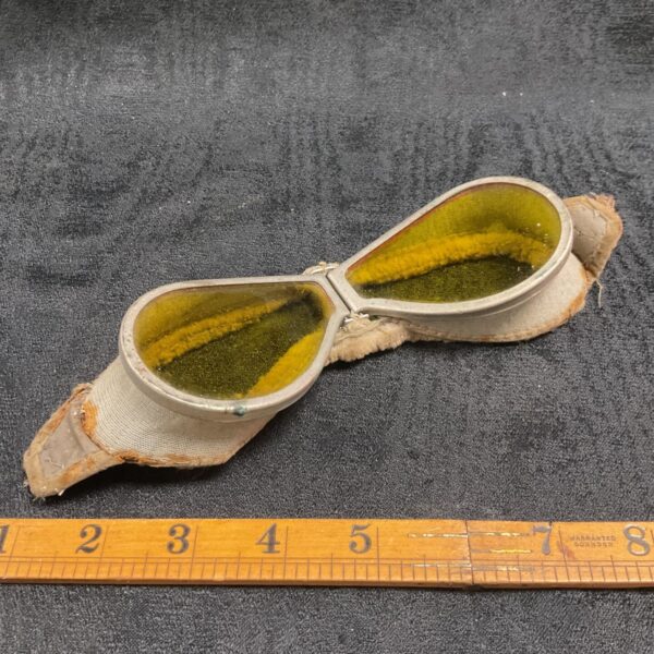 Antique aviator goggles with leather face shield and circular lenses.