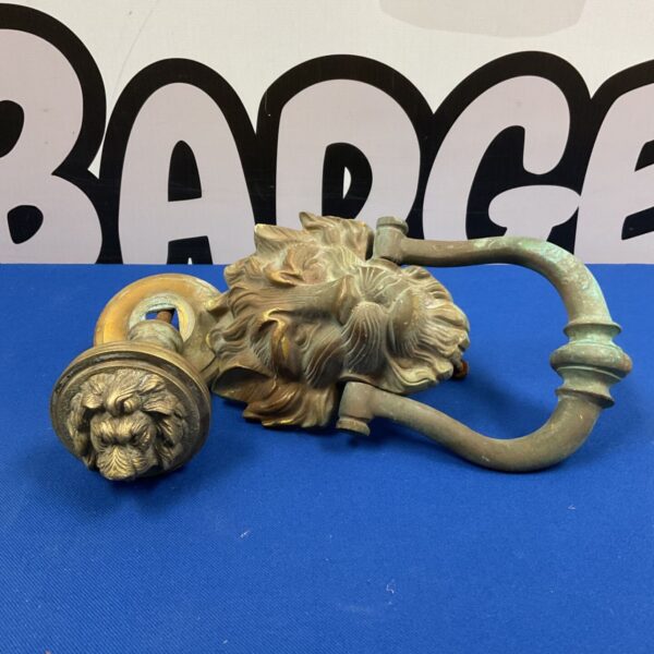 Antique brass lion door knocker with detailed mane.