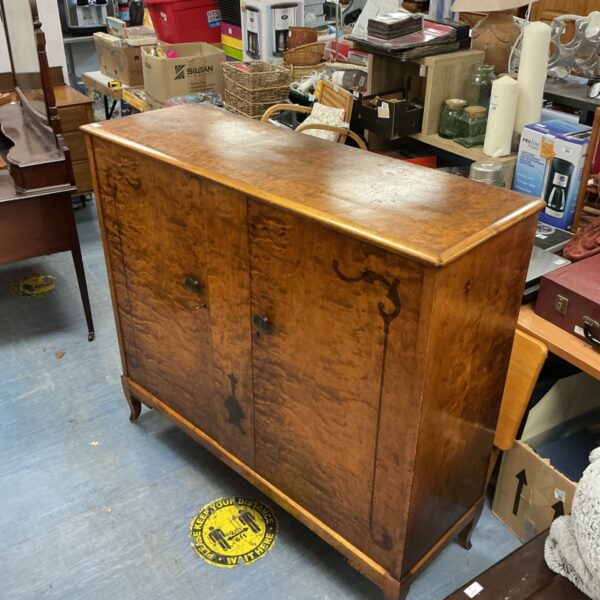 Antique burr walnut cupboard with detailed wood grain.