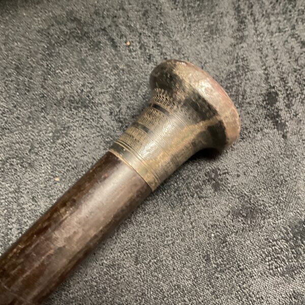 Close-up of antique walking cane silver topped ferrule.