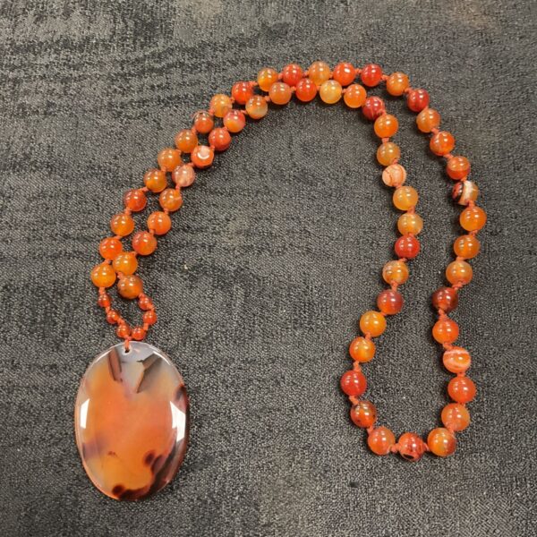 Antique carnelian bead necklace with a pendant, hand-knotted design.