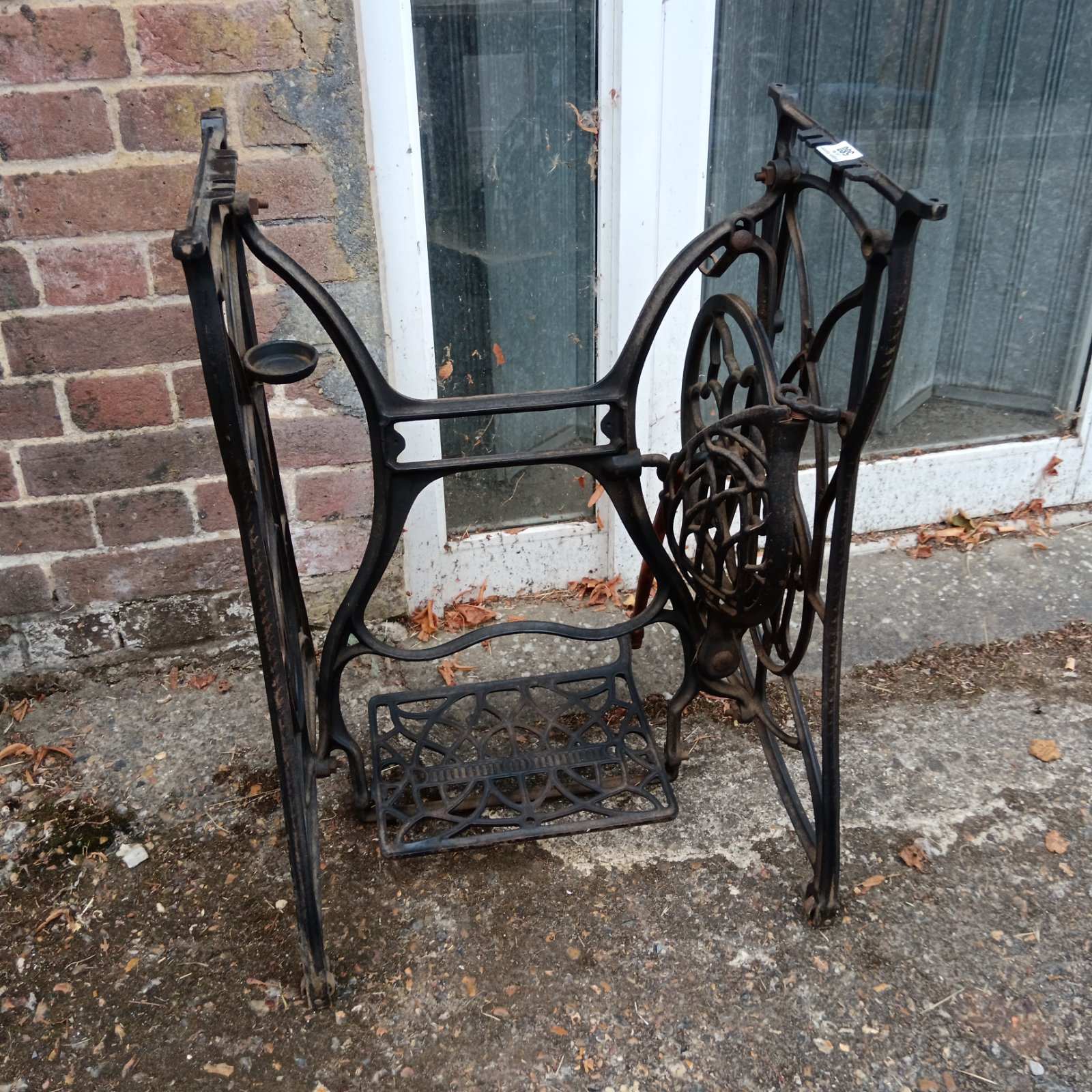 Antique cast iron treadle sewing machine base with ornate details.