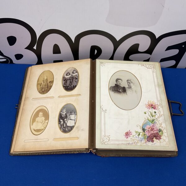 Antique photo album open with Victorian portraits.