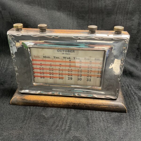 Antique silver desk calendar showing October month view.