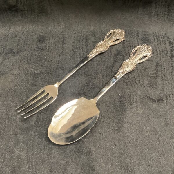 Antique silver serving set featuring ornate fork and spoon.