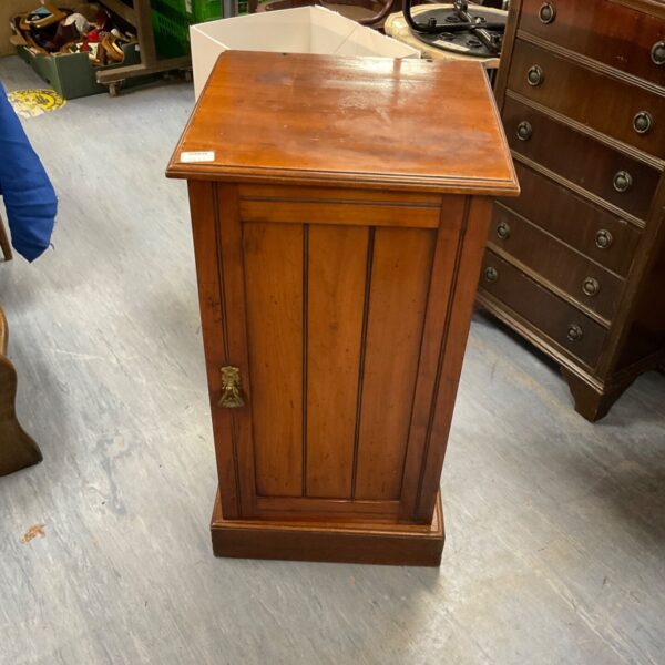 Antique walnut bedside cabinet with a single door and brass handle.