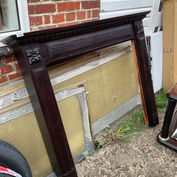 Intricate carved antique wooden fire surround for a fireplace.