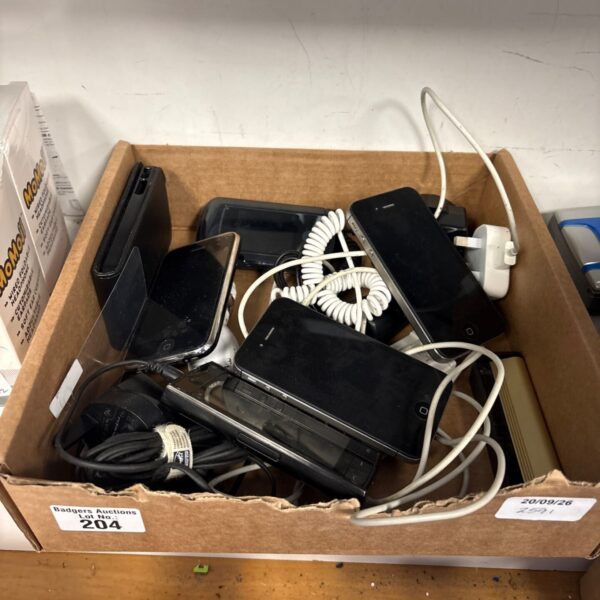 Box of used Apple iPhones and smartphone accessories.