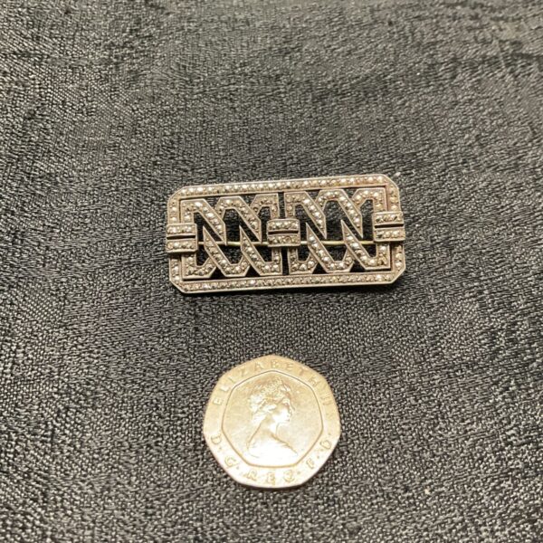 Close-up of an Art Deco silver marcasite brooch with intricate detailing.