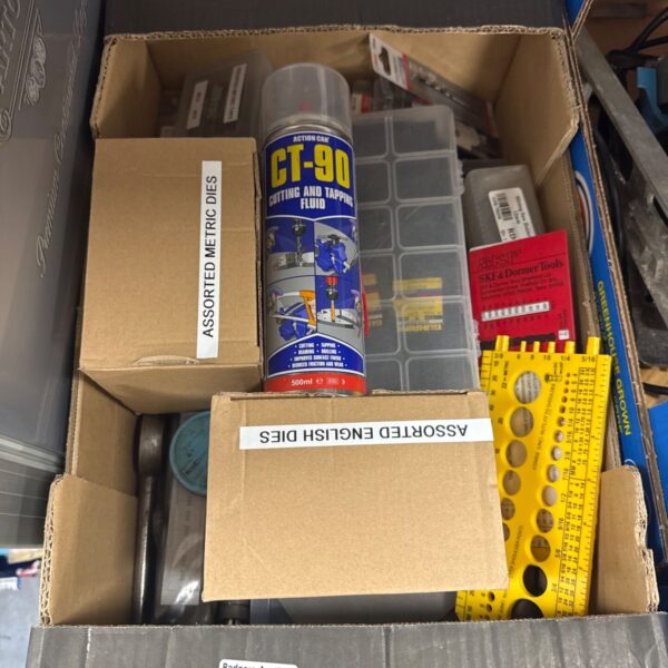 Tray of assorted metalworking dies, taps, and drill bits.