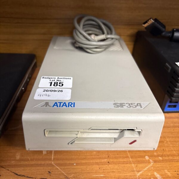 Vintage Atari SF354 floppy disk drive with cable connected.