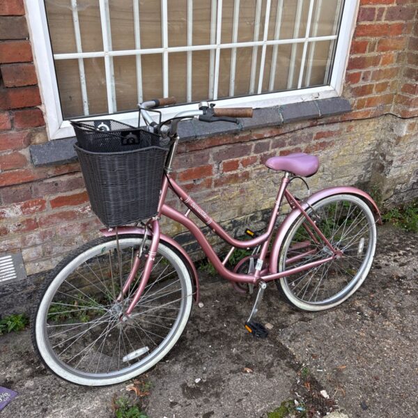 Purple Barracuda Lacerta ladies traditional bicycle with wicker basket.