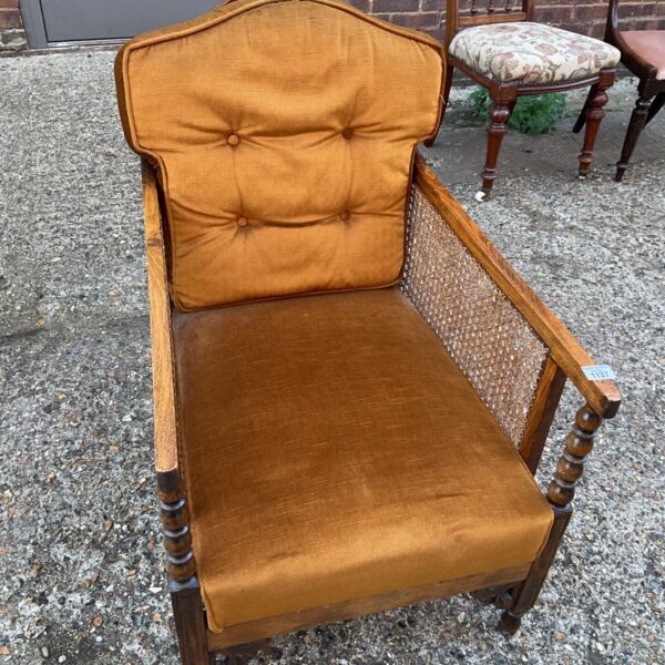 Vintage Bergere armchair with mustard gold velvet upholstery and cane sides.