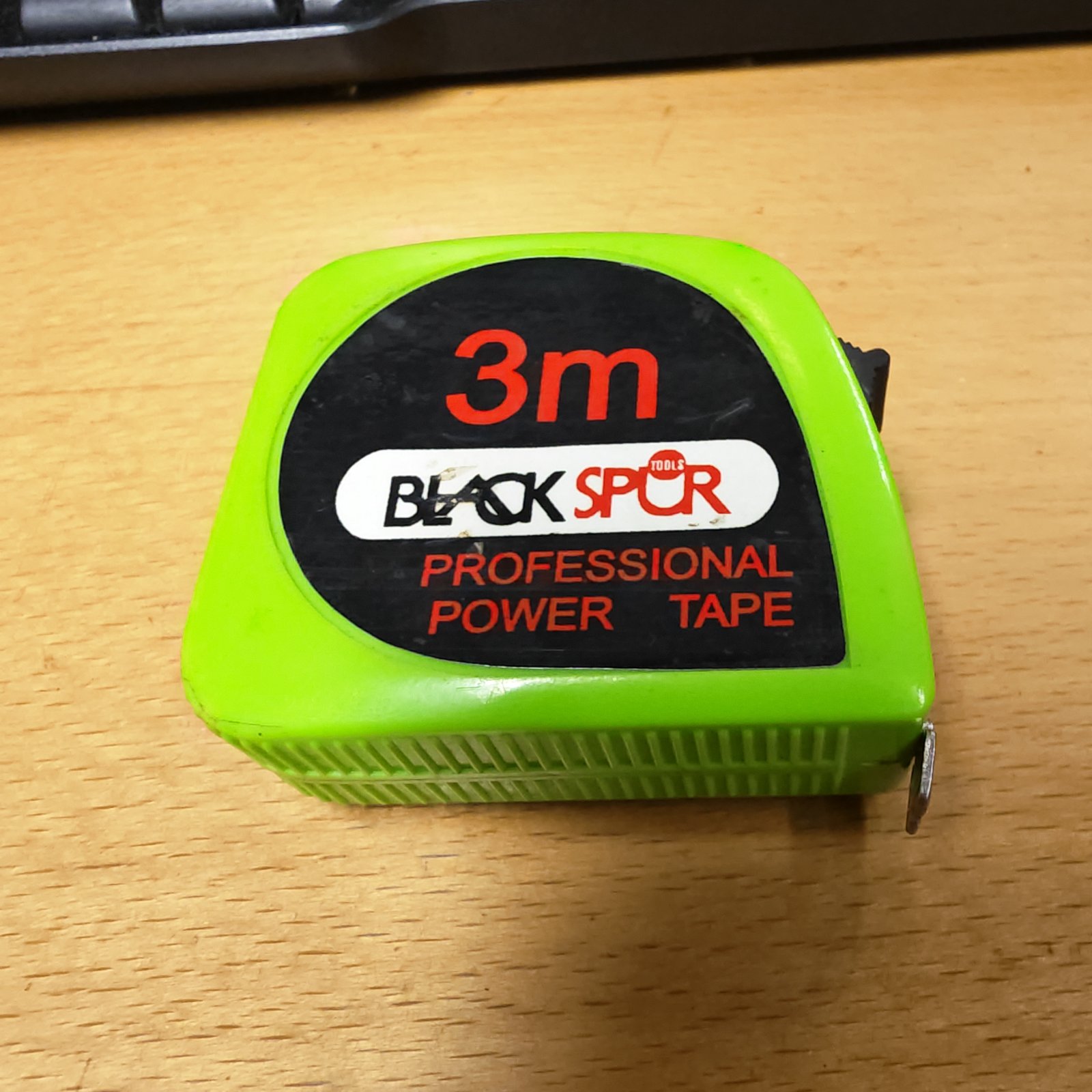 Black 3m tape measure with metric scale, showing signs of use.