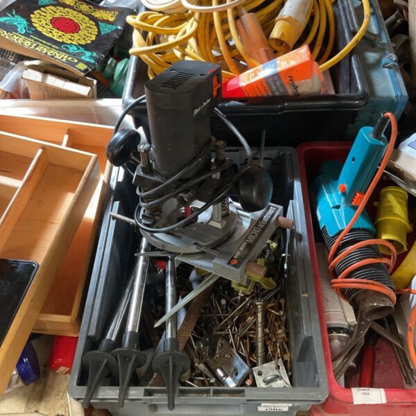 Black and Decker plunge router in a crate with nails and drill bits.