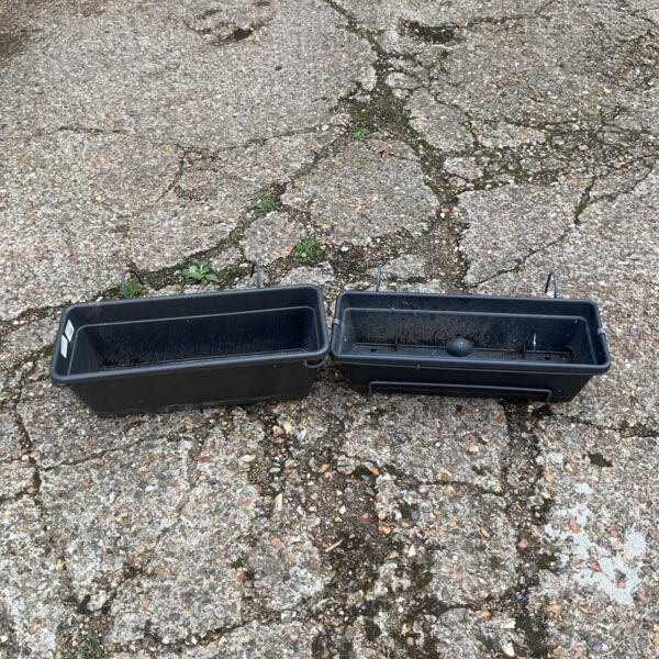 Two black plastic balcony planters for outdoor gardening.