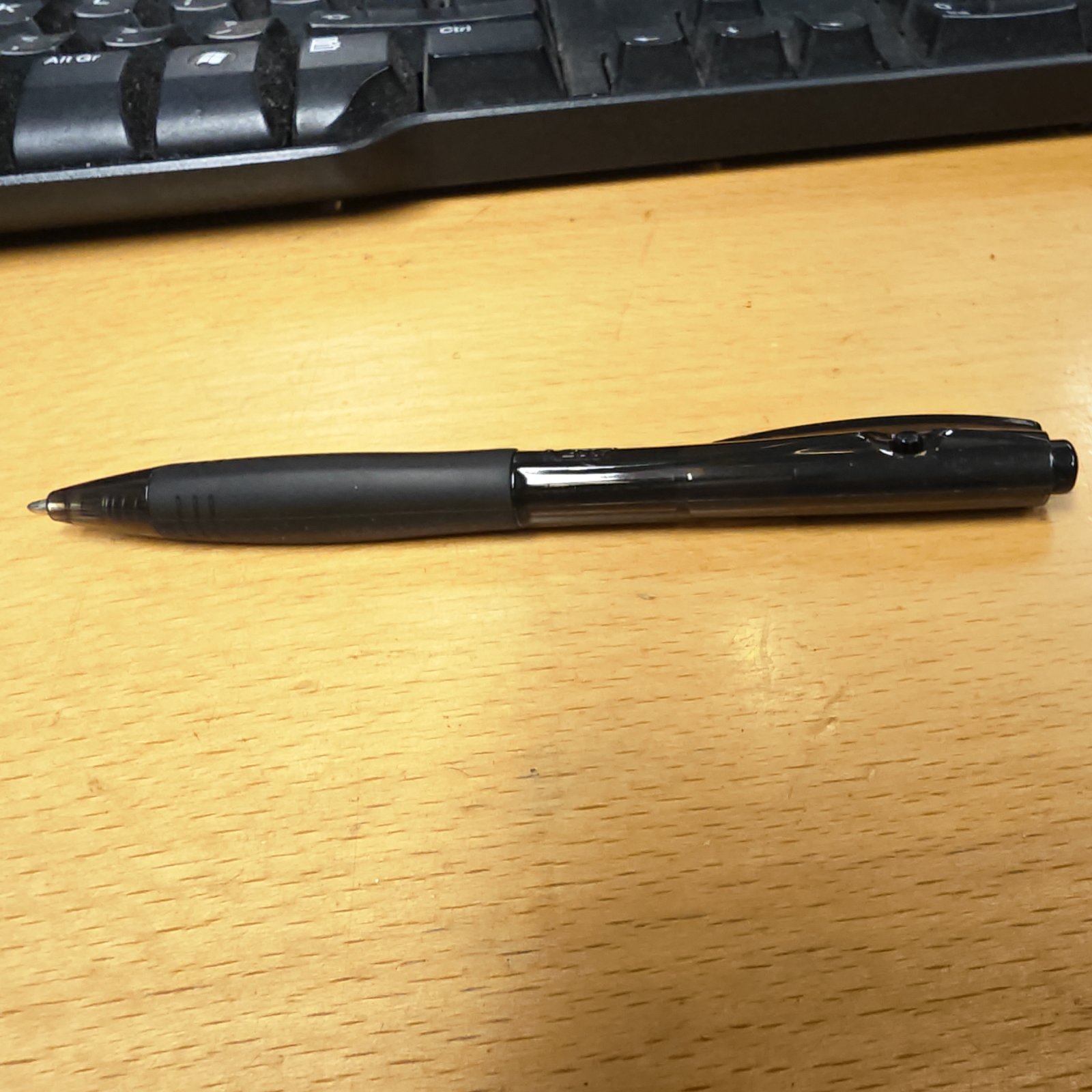 Black ballpoint pen on a desk, a classic writing instrument.