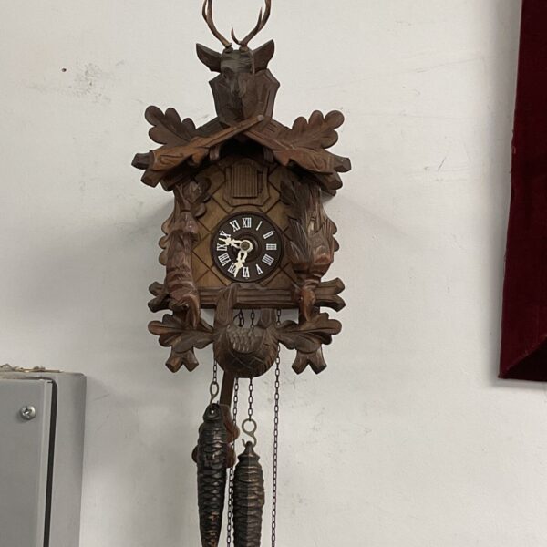 Vintage Black Forest cuckoo clock with detailed wooden carving.