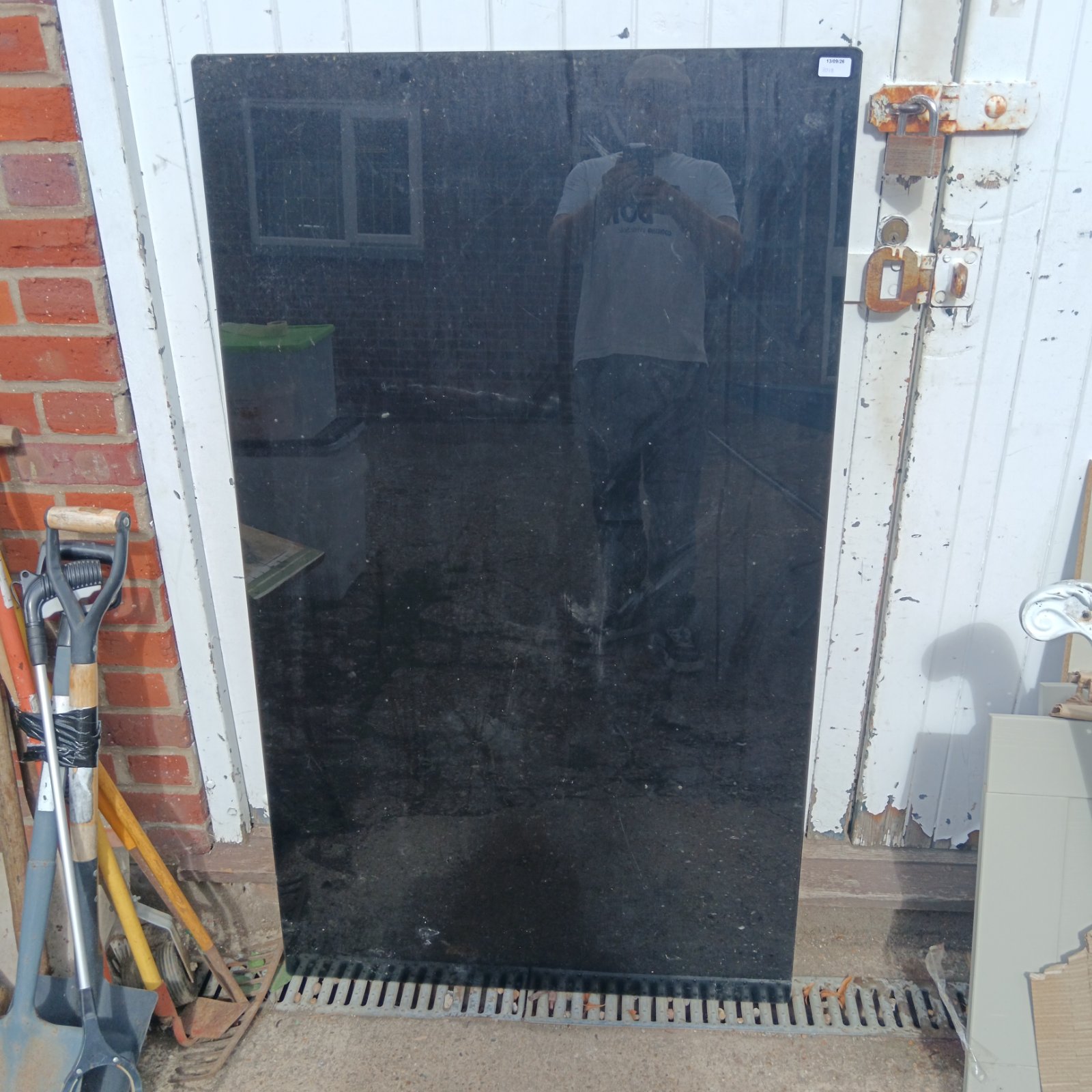 Black glass table top showing some wear and scratches.