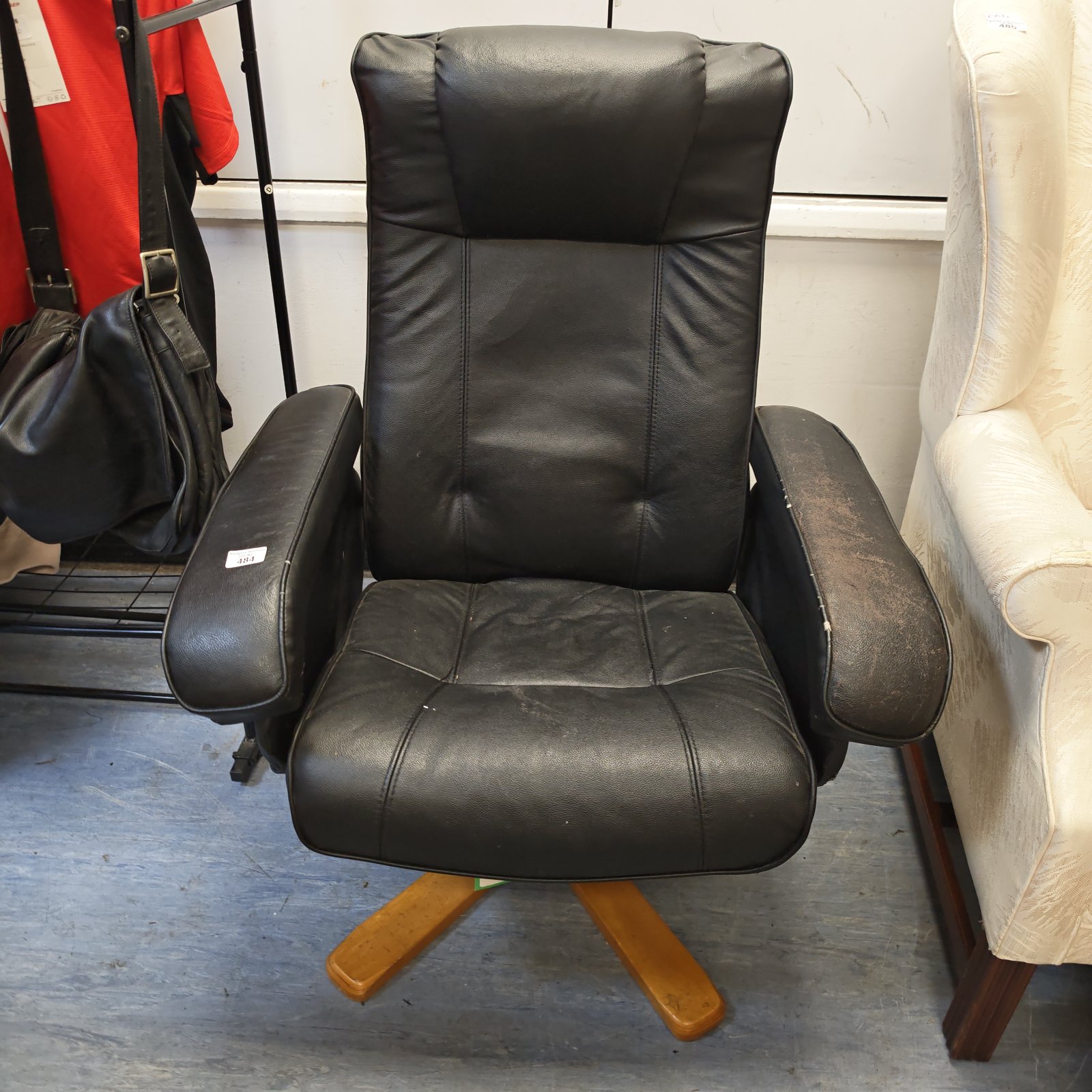 Vintage black leather recliner chair with wooden base.