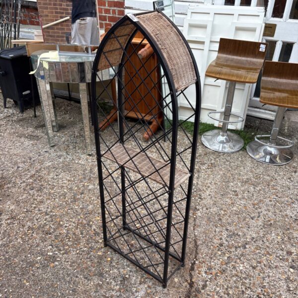 Tall black metal arched wine rack for wine storage.