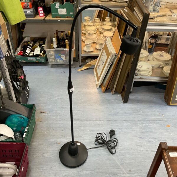 Black metal standard reading lamp with adjustable head.