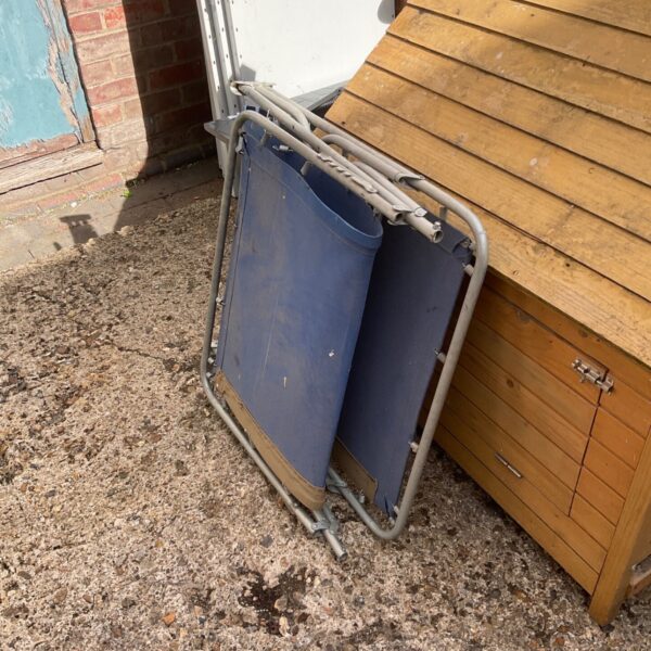 Blue folding sun lounger in a garden setting.